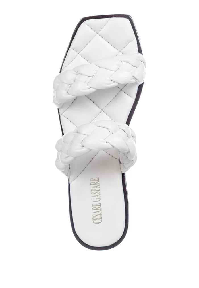 A pair of white soft leather flat sole sandals, showcasing high quality craftsmanship and comfort for any occasion.