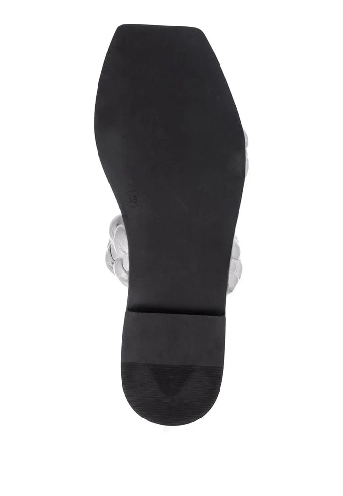 A pair of high-quality white leather flat sole sandals.