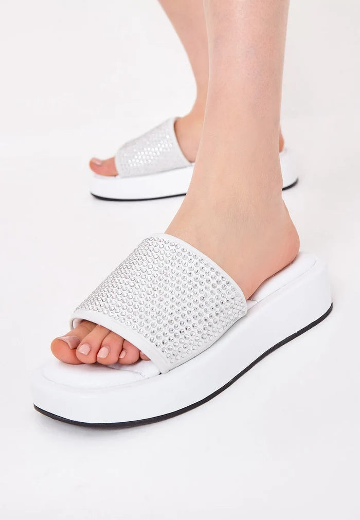 A stylish pair of white platform mule sandals adorned with jewel embellishments, perfect for women looking for high heel platform shoes and trendy fashion footwear.