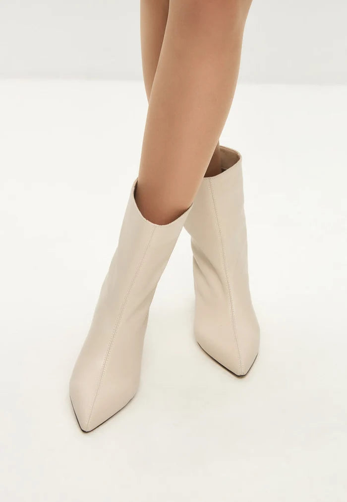 A stylish pair of trendy white kitten heel ankle boots for women, also known as Dolly ankle boots.