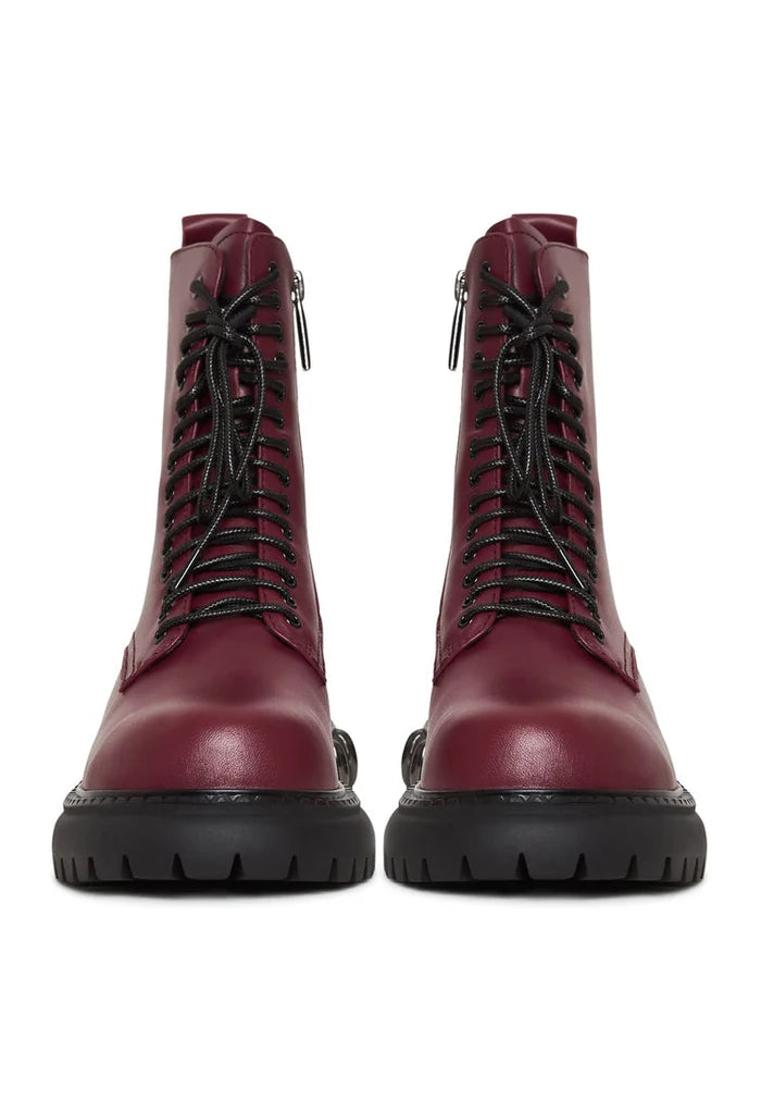 A close-up image of lace-up combat boots with a chunky sole in a trendy bordeaux color, a stylish choice in women's fashion footwear.