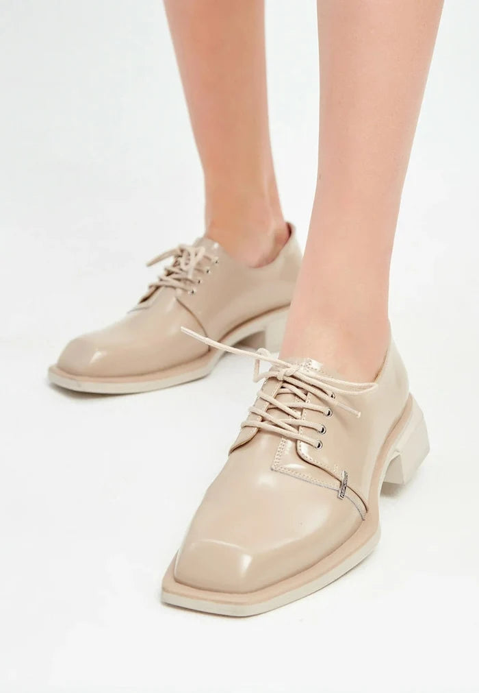 A stylish pair of beige leather lace-up loafers for men.