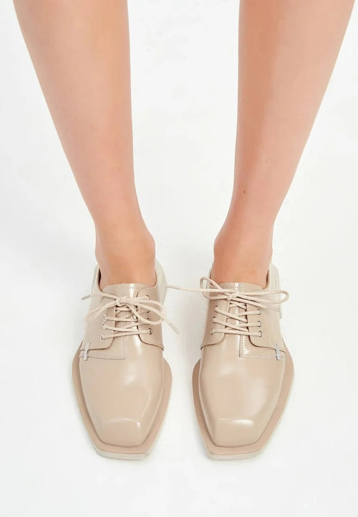 A stylish pair of beige leather lace-up loafers for men.