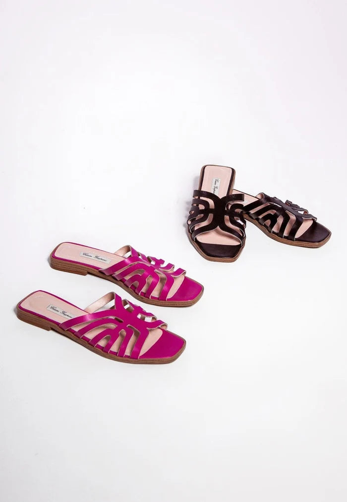 A close-up image of stylish black laser cut sandals, showcasing intricate laser cut design on the footwear.