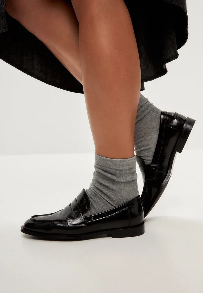 A stylish pair of black patent leather block heeled loafers, perfect for women's everyday wear.