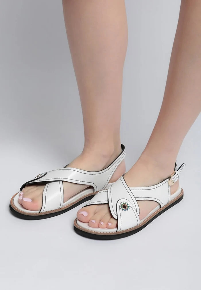 A trendy pair of stylish leather flat sandals with a flat sole, perfect for urban fashionistas.