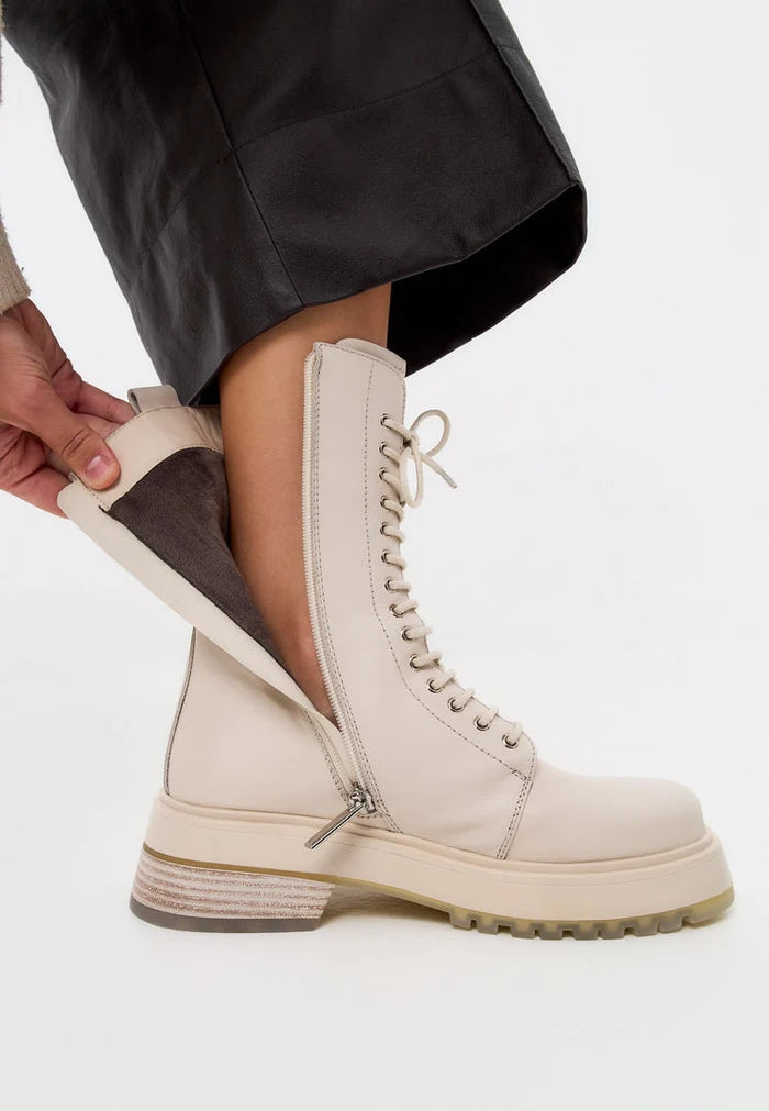 A trendy pair of beige lace-up leather ankle boots for women - perfect fashion boots for any outfit.
