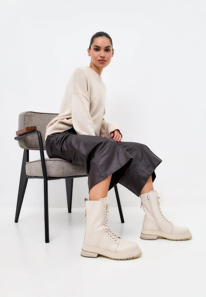 A stylish pair of women's leather lace-up ankle boots in beige, perfect for the latest fashion trends.