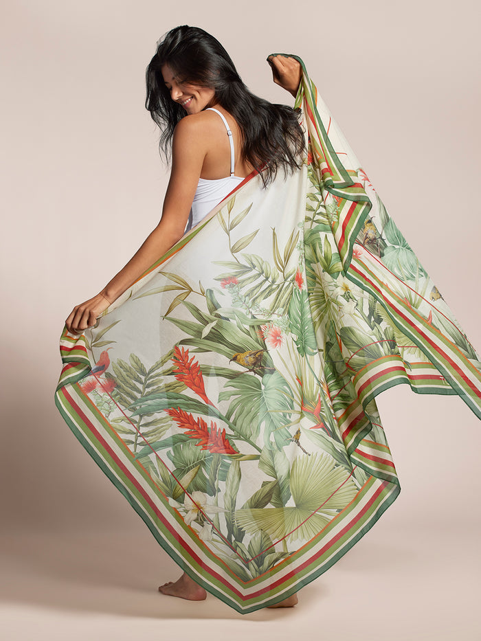 White Manu Garden pareo with green, red, and beige border, held by woman in tank top.