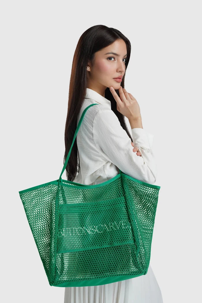 woman carrying mesh tote bag lagoon by buttonscarves