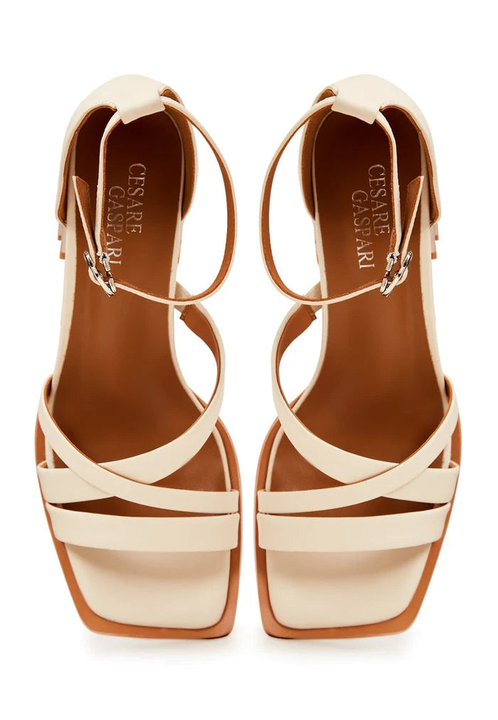 A pair of stylish beige leather open toe block heel sandals for women.