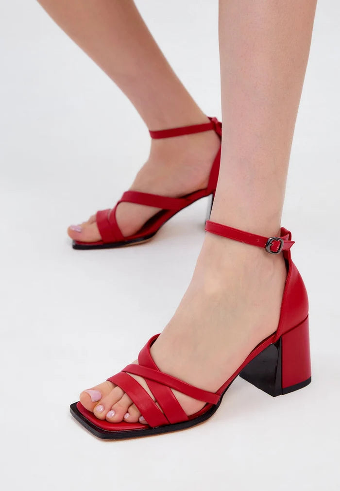 A stylish pair of red leather block heel sandals with an open toe design, perfect for summer wear as women's footwear.