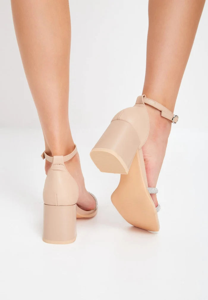 A pair of stylish beige leather block heeled sandals with an open toe design, perfect for completing any chic outfit.