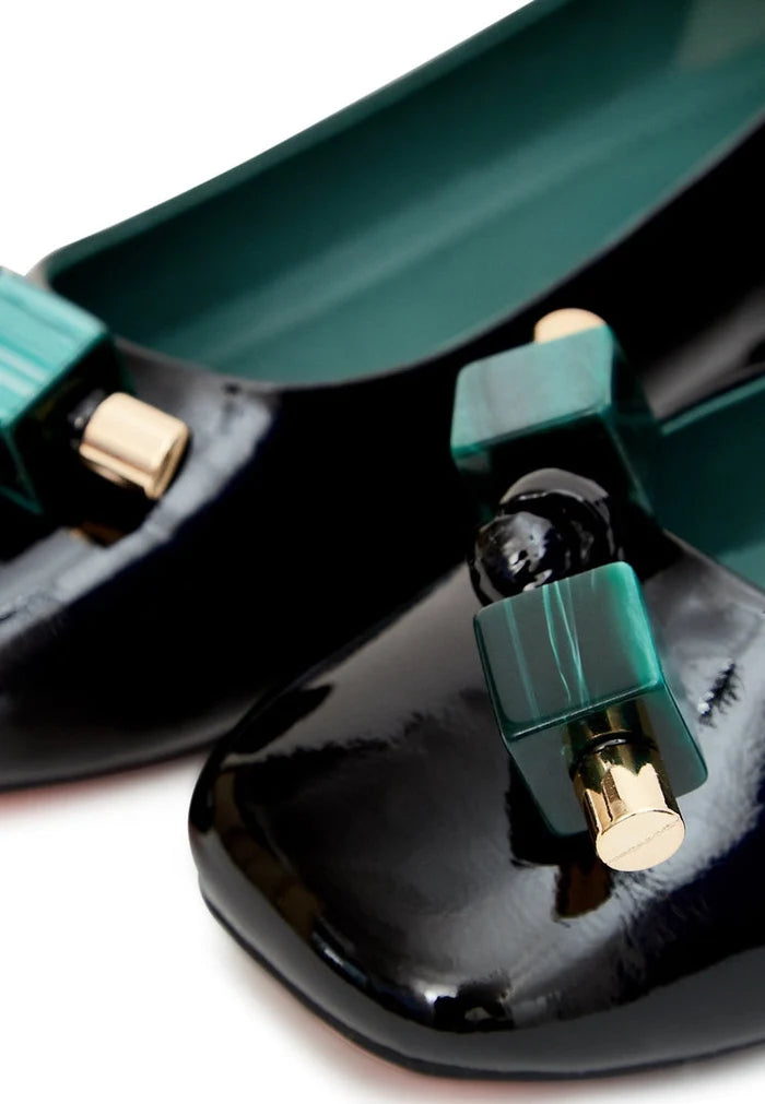 A stylish pair of women's black ballet flats in patent leather with embellishments.