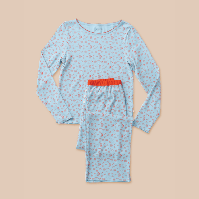 Flatlay of Cozyland French Blue pajama set with long-sleeve top and pants, small red print and contrast red waistband