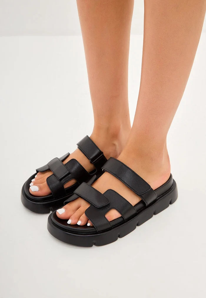 A close-up image of Kati platform mules in black, featuring a sleek and stylish design with a comfortable platform sole.