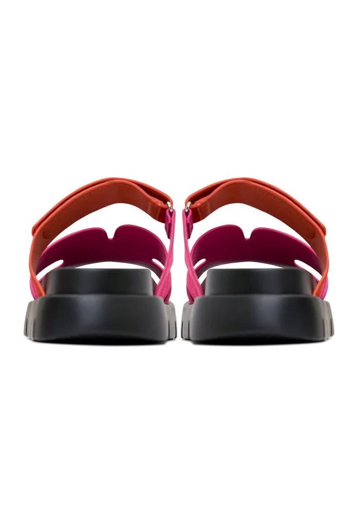Rear view of stylish kati platform mules in vibrant pink, featuring thick black soles for a trendy look. Ideal for fashion-forward individuals seeking pink platform mules with a bold statement.