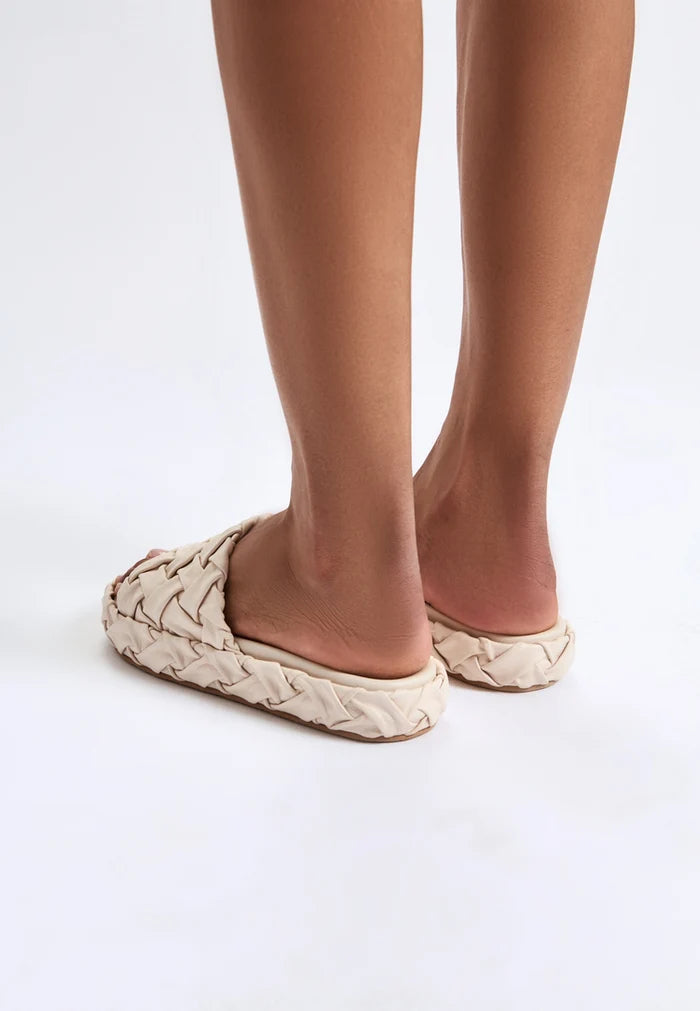 A stylish pair of beige platform slippers known as the Antonella platform sandals - trendy women's platform shoes offering comfort and style.