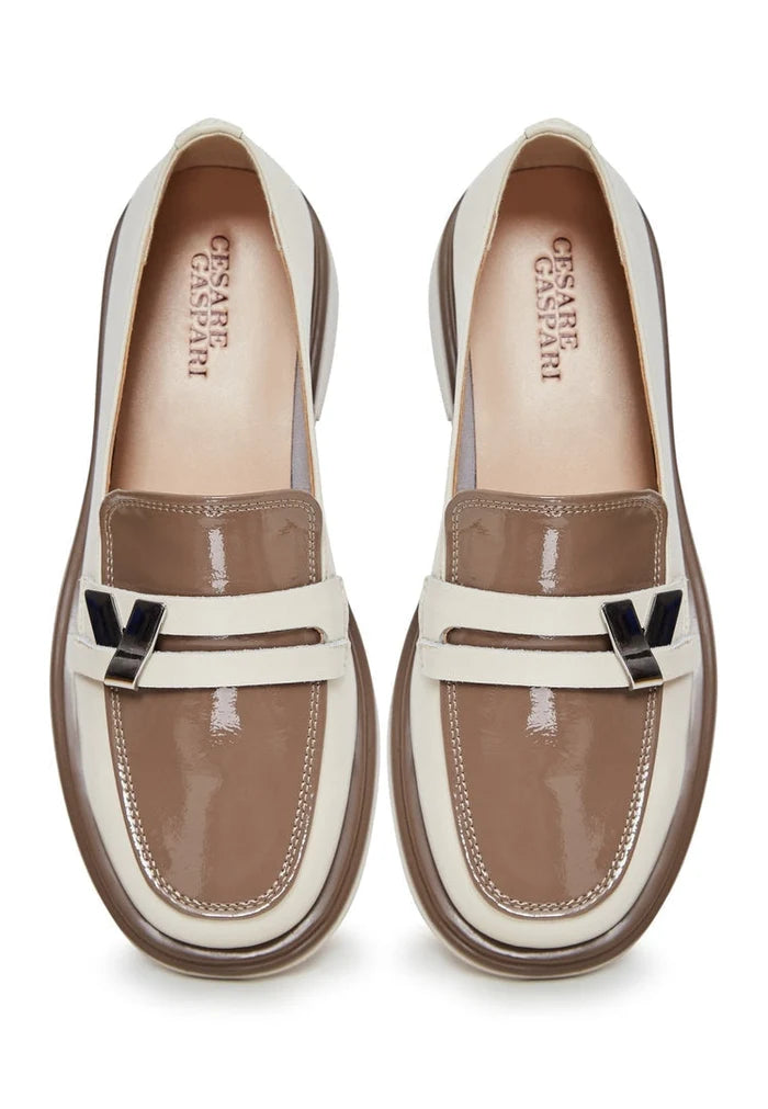 A stylish pair of beige slip-on loafers with a round tip block heel for women, perfect for a fashionable and comfortable look.