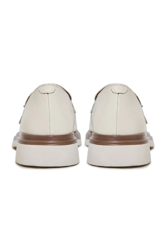 A stylish pair of women's round tip block heel loafers in beige, perfect slip-on shoes for a fashionable look.