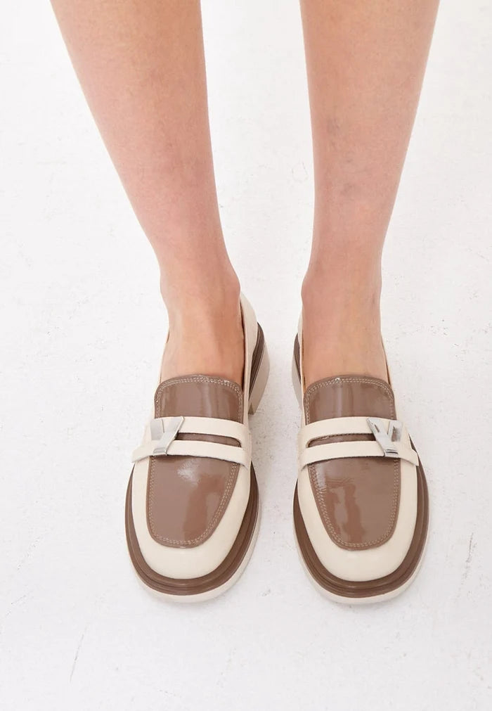 A stylish pair of women's slip-on loafers in beige, featuring a round tip block heel - perfect for a fashionable look.