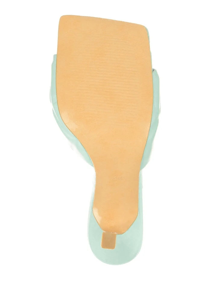 A stylish blue leather mule with a square toe, chunky heel, and elegant design for women.