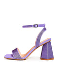 A pair of elegant lilac strappy block heel sandals adorned with sparkling rhinestones, perfect for a glamorous evening out.