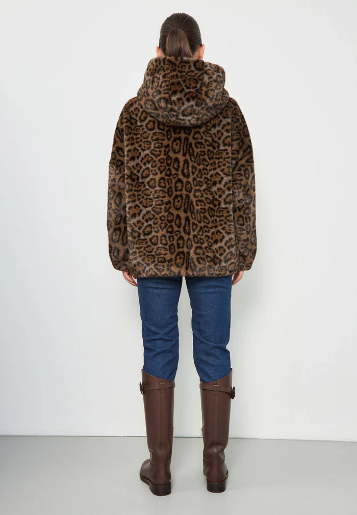 A fashionable woman wearing a stylish faux fur hooded leopard jacket, the Reyna leopard jacket, a trendy women's jacket perfect for the season's faux fur outerwear trend.