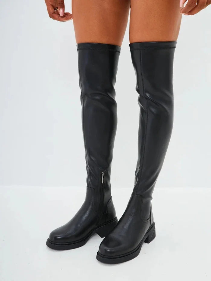 A fashion-forward woman wearing chic over-the-knee suede boots - the ultimate in stylish women's footwear.