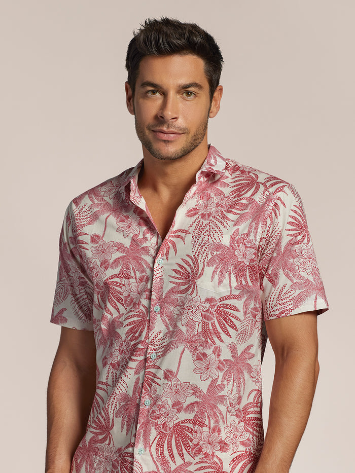 Pink and white floral palm-print short-sleeve cotton shirt, front view of a man, plain background.