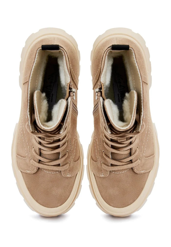 A stylish woman wearing trendy lace-up ankle boots, perfect for a fashionable street style look.