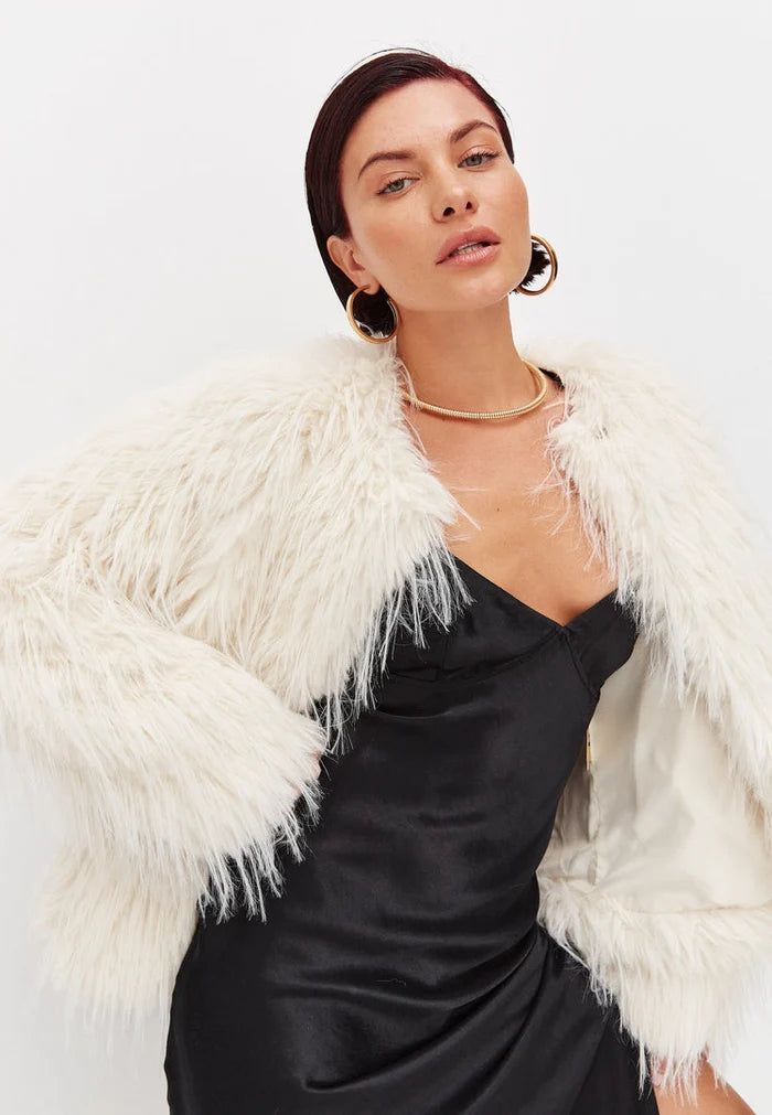 A stylish white faux fur winter jacket, perfect for cold weather outerwear, that is both fashionable and cozy.