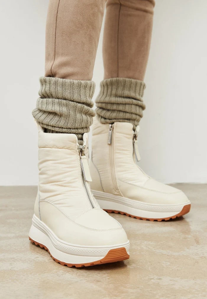 A pair of stylish ivory platform winter boots for women, perfect for cold weather and winter fashion footwear.