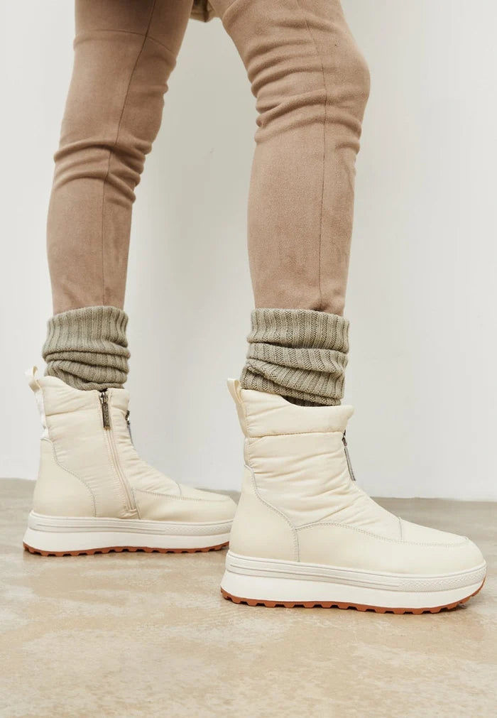 A pair of stylish ivory platform winter boots for women, perfect for keeping your feet warm and on-trend this season.